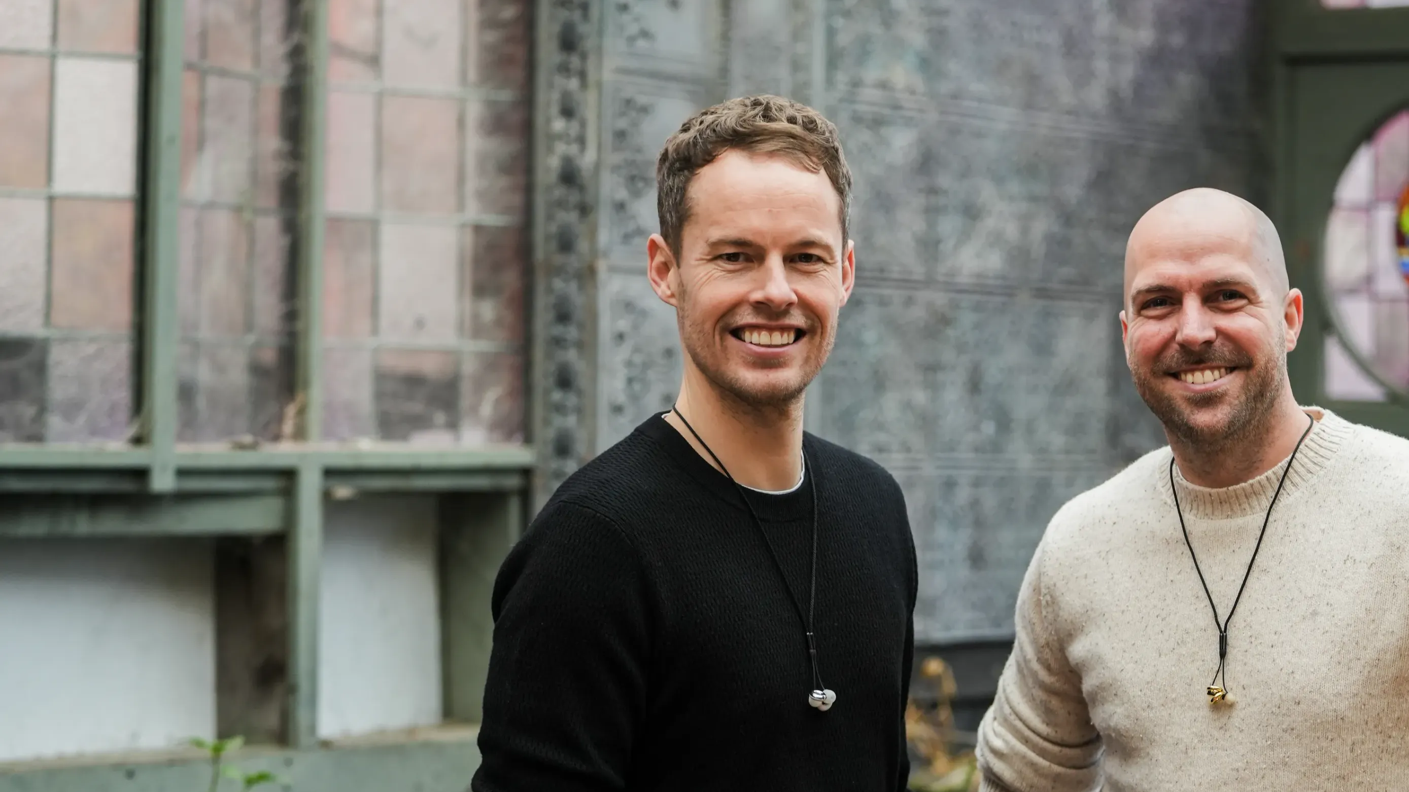 Loop Earplugs cofounders Dimitri & Maarten standing in front of a building with stained glass windows.