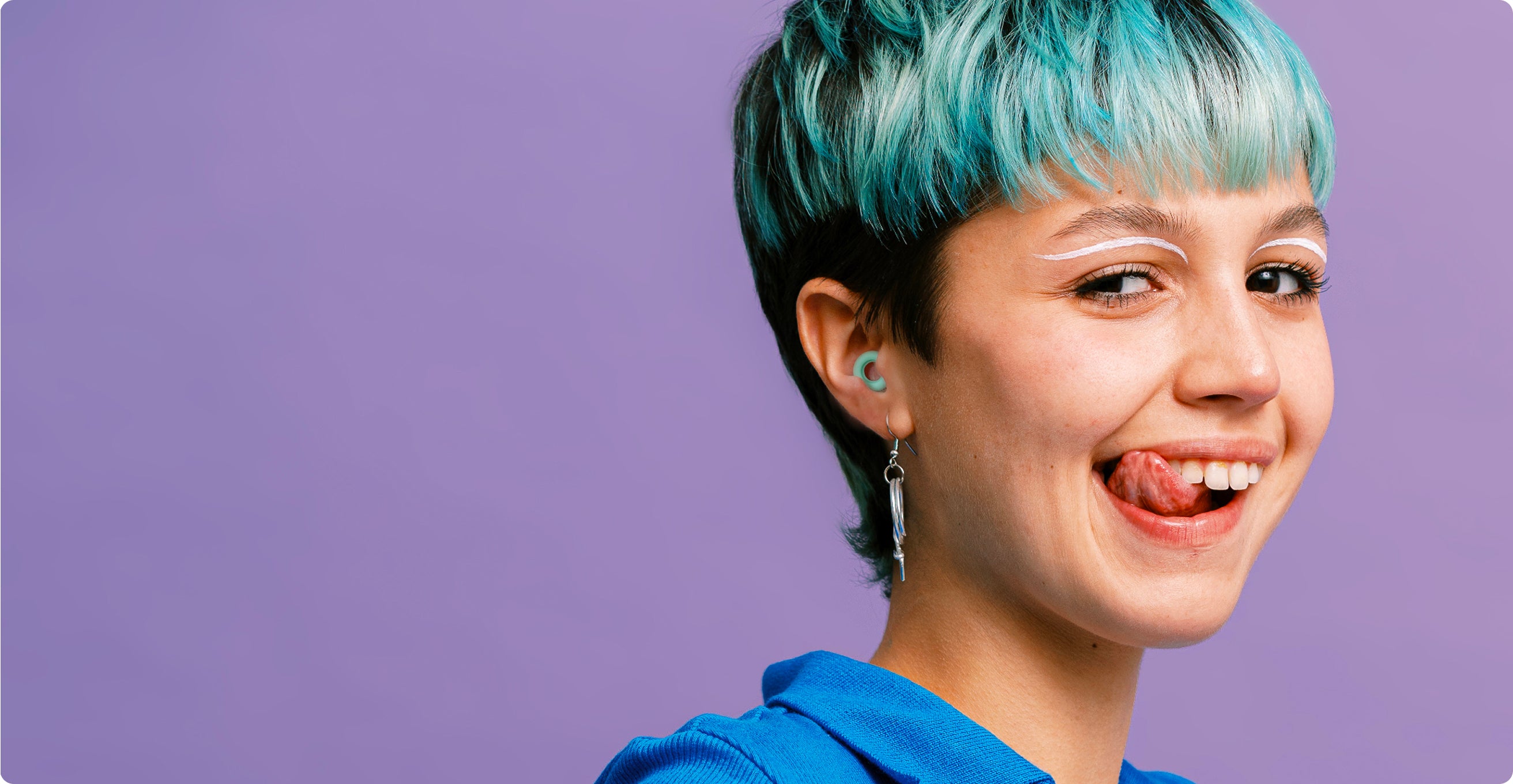 Person with blue hair and a blue top against a purple background