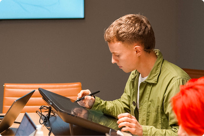 Person using a digital drawing tablet in an office setting